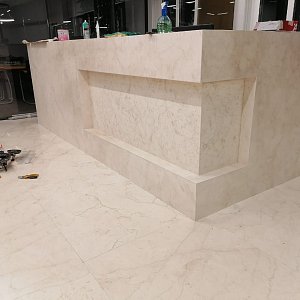 Стойка ресепшн, полы из мрамора Crema Nuova